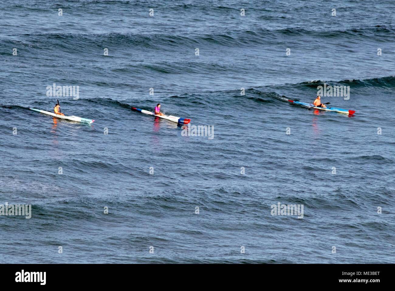 Drei Leute auf Surf Kajaks Fang eine Welle an der Gold Coast in Australien Stockfoto