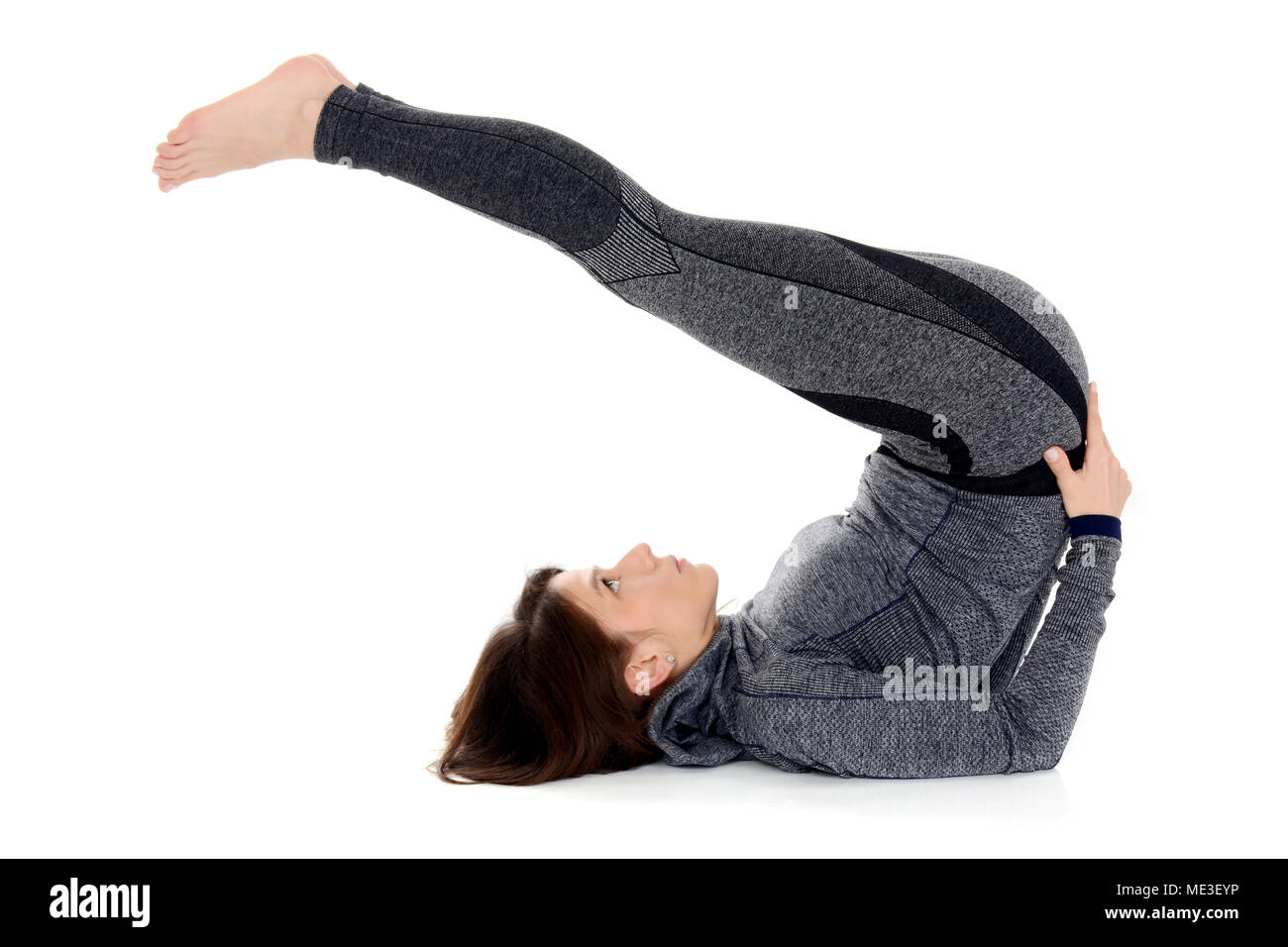 Junge Frau Yoga Asana Halasana Pflug darstellen Stockfoto