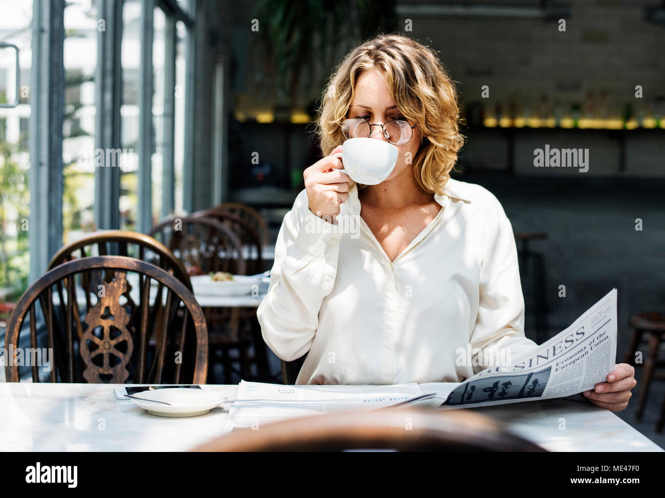 Business Frau liest Zeitung am Morgen Stockfoto