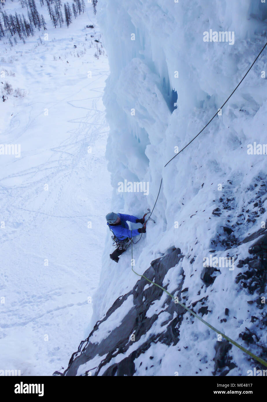 Männliche Eiskletterer auf einem steilen Eisfall in den Schweizer Alpen in der Nähe von Davos. Stockfoto