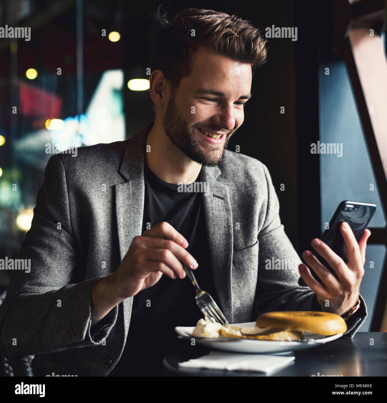 Mann Lesen von Nachrichten auf seinem Mobiltelefon Stockfoto