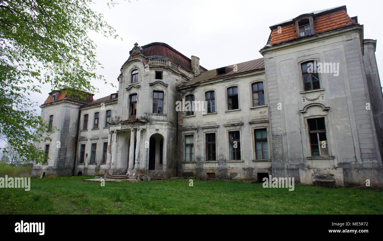 Ein großes, baufälliges Herrenhaus steht im Verfall, die Fassade ist von Vegetation bedeckt, Zeichen des Verfalls. Die alternde Struktur, einst ein Symbol für Luxus, Stockfoto