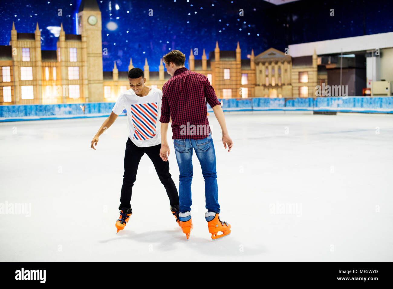Freunde, die zusammen Spaß Eislaufen auf der Eisbahn Stockfoto