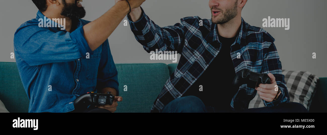 Männer spielen Video Game auf dem Sofa geben einen hohen fünf Freizeitaktivitäten und Teamarbeit Konzept Stockfoto