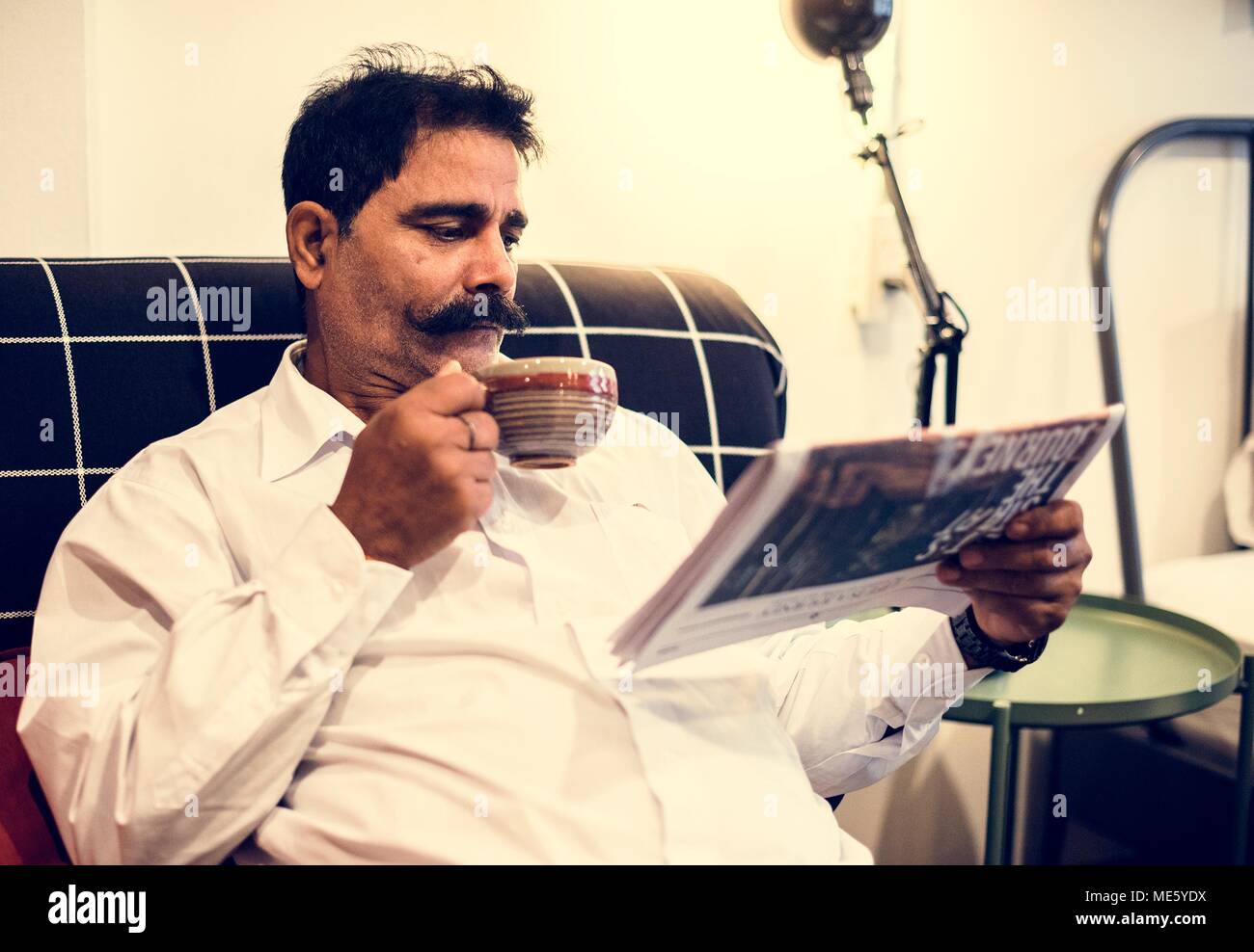 Indischer Mann lesen Zeitung Stockfoto