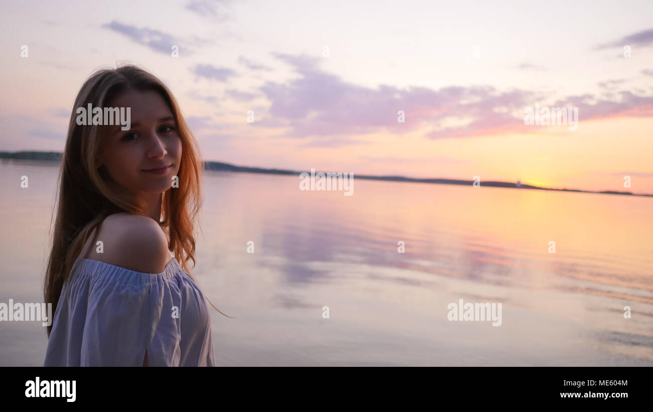Junge Mädchen im Hintergrund auf das Meer und den Sonnenuntergang. Stockfoto