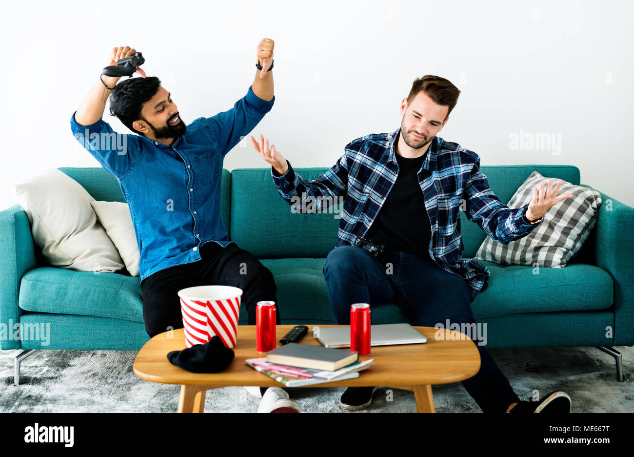 Männer spielen Video Game auf dem Sofa Stockfoto