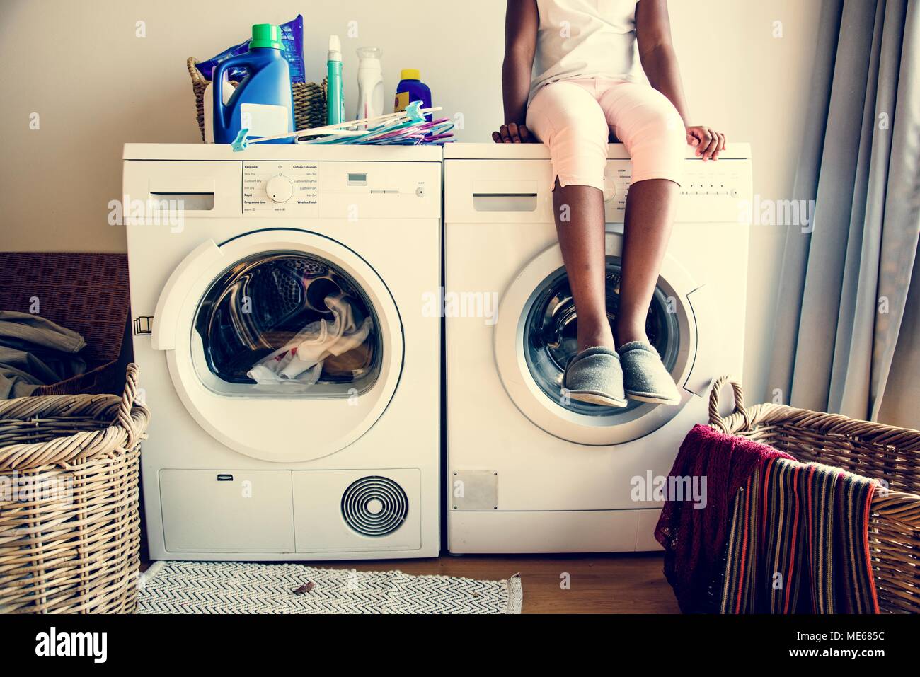 Junge jugendlich Mädchen warten auf Kleiden von Waschmaschine gewaschen werden. Stockfoto