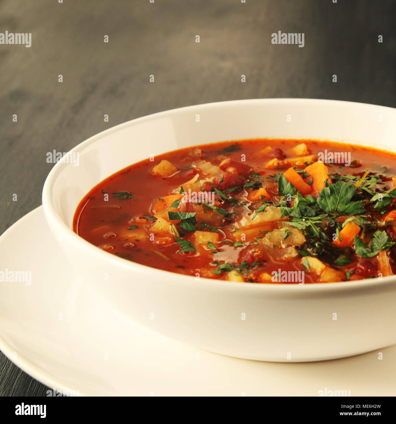 Tomatensuppe mit roten Bohnen, Kartoffeln und Karotten. Vegane Ernährung. Europäische Küche. Vegetarisches Gericht. Hauptgericht. Bio Mahlzeit. Getönten Foto. Stockfoto