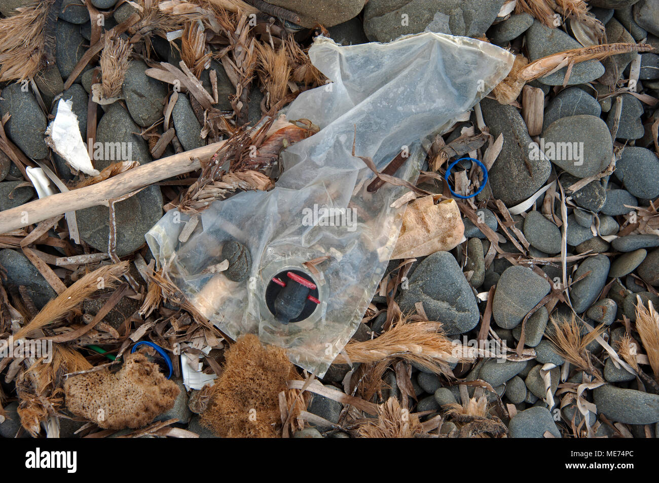 Kunststoffabfälle an einem Kiesstrand an der nördlichen Küste der Insel Menorca Spanien Stockfoto