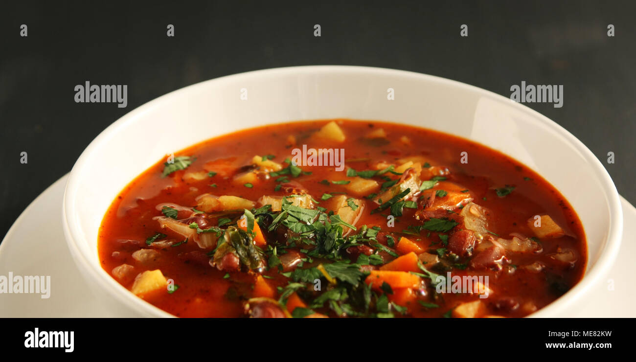 Tomatensuppe mit roten Bohnen, Kartoffeln und Karotten. Vegan. Europäische Küche. Von der Seite. Vegetarisches Gericht. Hauptgericht. Breite Foto. Stockfoto