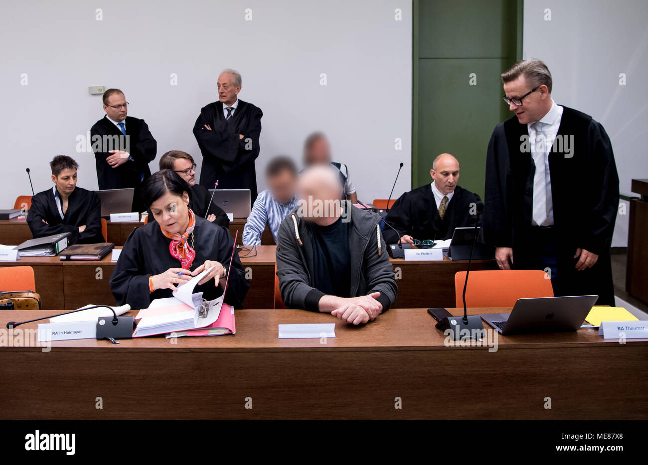 20 April 2018, Germany, München: Rechtsanwalt Margrete Haimayer (1. Zeile, Front l-r), Rechtsanwalt Frank Theumer (stehend), Rechtsanwalt Bettina Lindner (2. Zeile, l-r), Rechtsanwalt Oliver Wallasch, Rechtsanwalt Michael Pfefferl, Rechtsanwalt Markus Noehring (steht auf der Rückseite, l-r), Rechtsanwalt Gerhard Bink, und der Beklagten (pixelig) sitzen sie bei Gericht, mit betrügenden Investoren von rund 60 Millionen Euro belastet. Verfolger glauben, dass rund 5830 Menschen, die von finanzieller Betrug der Angeklagten beschädigt wurden. Foto: Sven Hoppe/dpa Quelle: dpa Picture alliance/Alamy leben Nachrichten Stockfoto