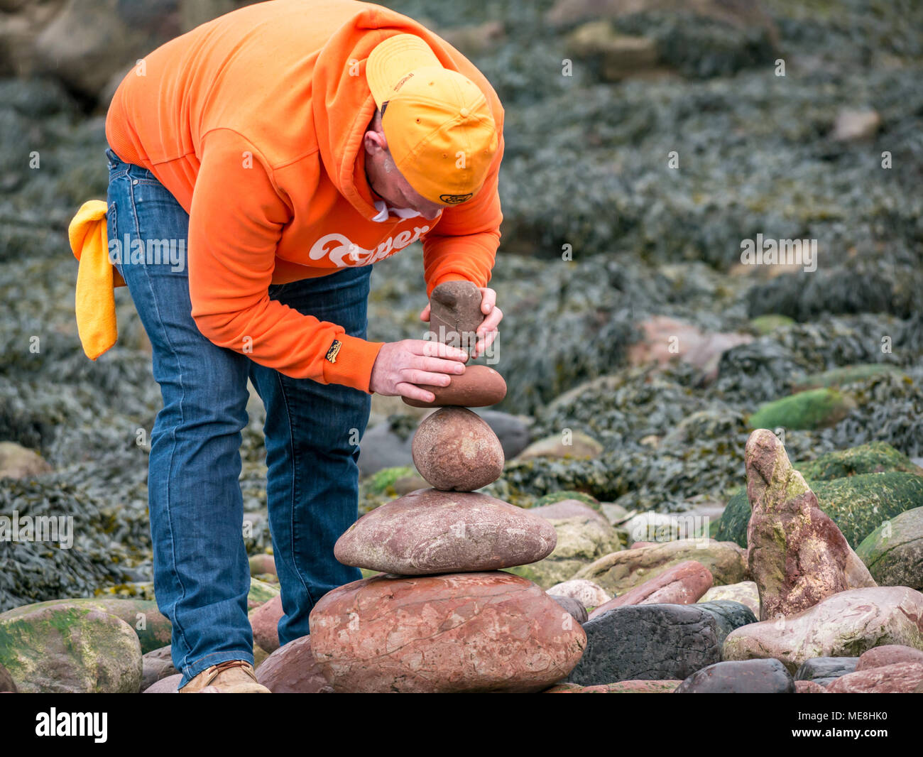 Dunbar, Schottland, 22. April 2018. Auge Cave Strand, Dunbar, East Lothian, Schottland, Vereinigtes Königreich, 22. April 2018. Der zweite Tag des zweiten Europäischen Stein stacking Meisterschaften an diesem Wochenende in Dunbar, von Dunbar Street Art Prozess organisiert. Konkurrenten kam aus Schottland, Großbritannien, Frankreich, Österreich, den USA und Spanien. Der erste Wettbewerb des Tages war die Anzahl der Steine in 20 Minuten. Der Gewinner ausgeglichen 29 Steine, etwas weniger als im letzten Jahr, gewann 32 Steine. Ein Konkurrent baut ein Stein Stapel Stockfoto