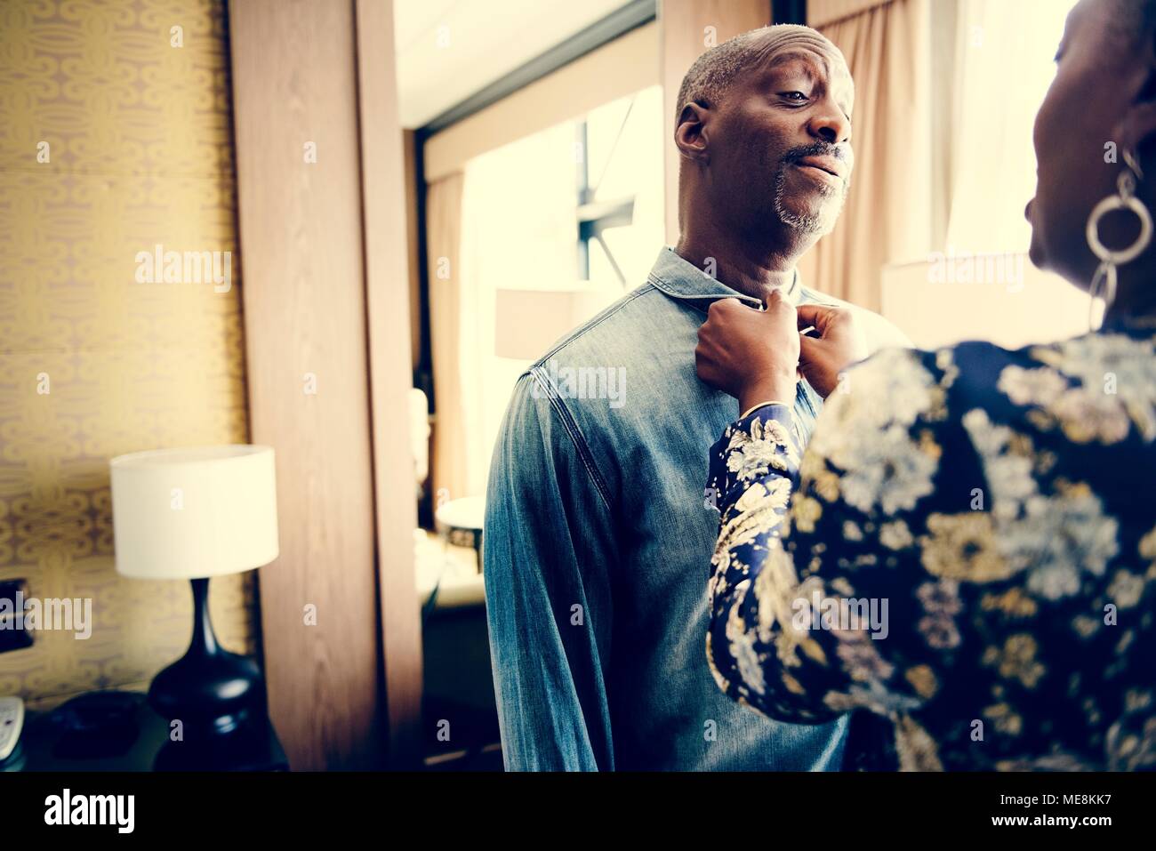 Frau ihrem Partner helfen in Dressing up Stockfoto