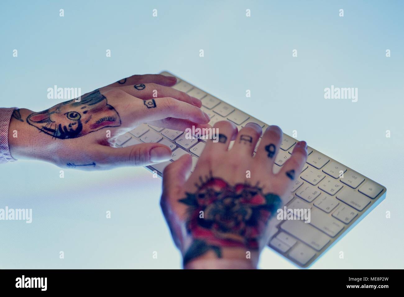 Hände mit Tattoo die Eingabe über die Tastatur Stockfoto