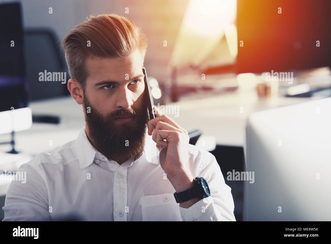 Unternehmer im Gespräch mit dem Telefon im Büro Stockfoto