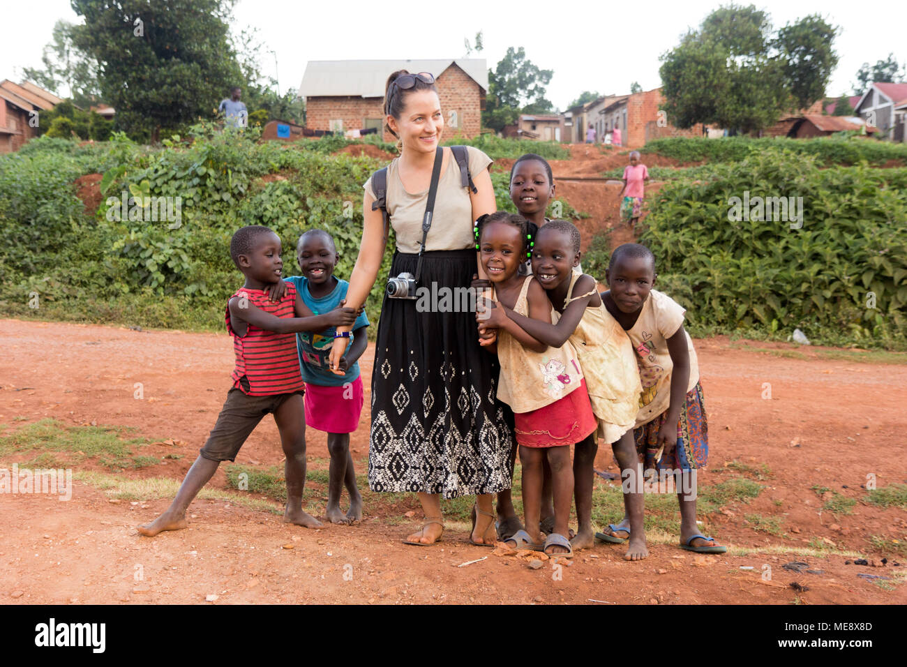Lugazi, Uganda. 17. Mai 2017. Eine weiße Hautfarbe freiwillige ('mZungu' oder 'muzungu' lokal) Hände mit ugandischen Kinder in einer ländlichen Gegend. Stockfoto