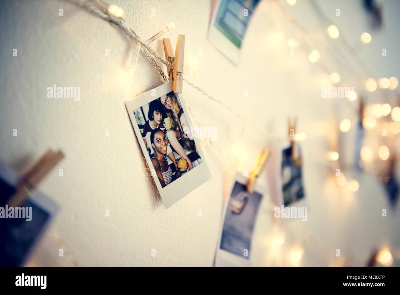 Fotos hängen mit Deko Leuchten auf der weißen Wand Stockfoto