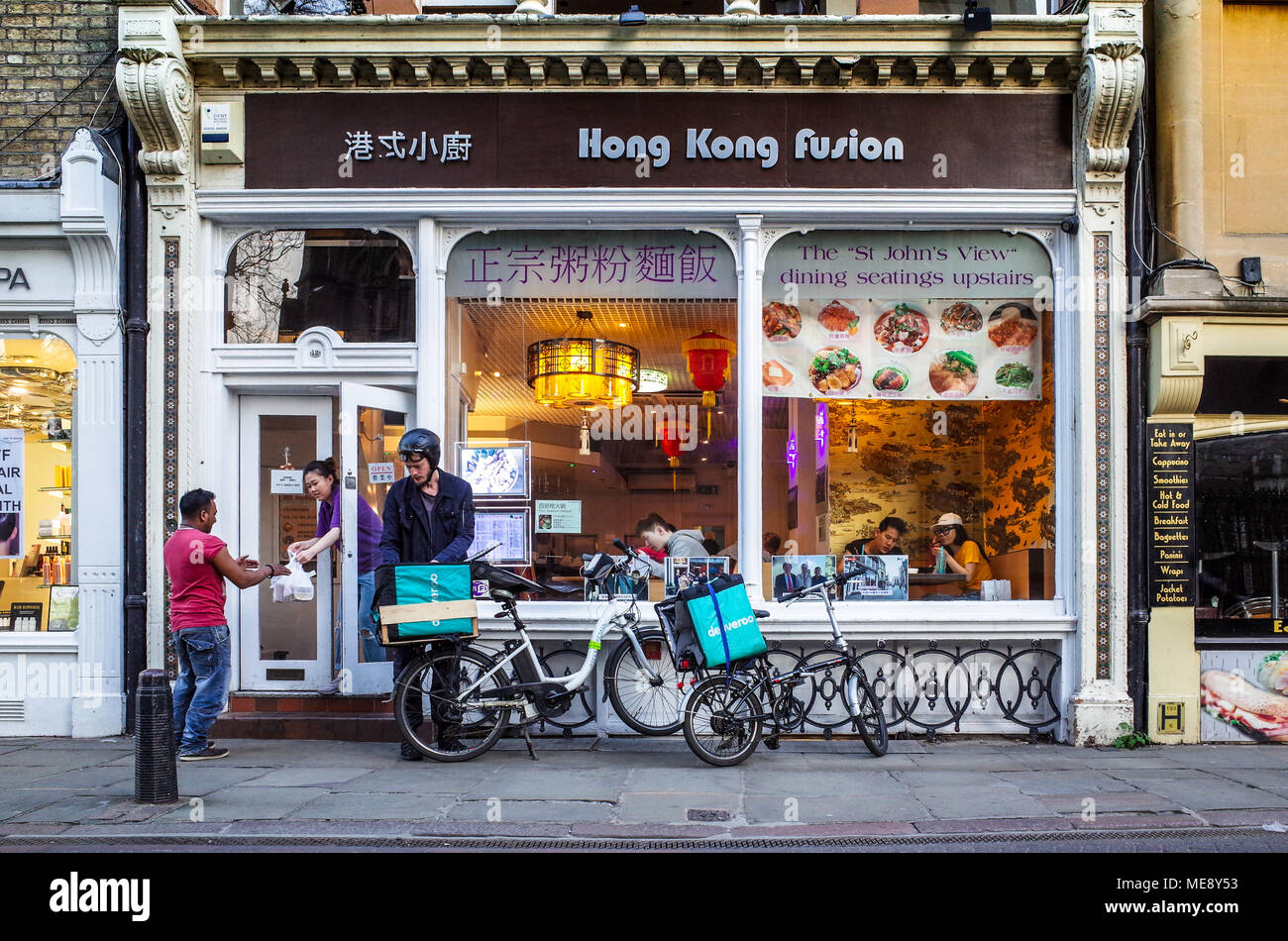 Deliveroo Lebensmittel-lieferservice Kuriere holen Sie Mahlzeiten zum Mitnehmen aus dem Hong Kong Fusion Restaurant im Zentrum von Cambridge Großbritannien Stockfoto