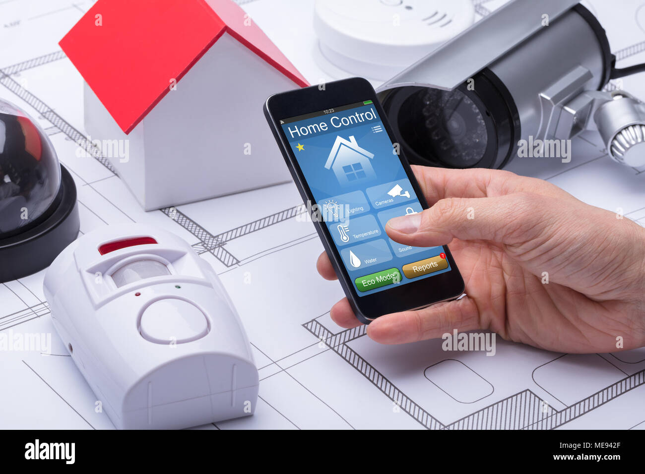 In der Nähe von Hand und mit Hilfe des Architekten Home Control System auf Mobiltelefon über Blueprint Stockfoto