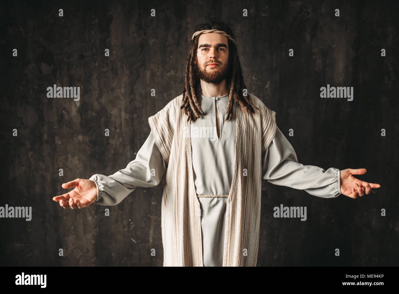 Jesus Christus in ein weißes Gewand beten mit offenen Armen, dunklen Hintergrund. Sohn Gottes, christlichen Glauben Stockfoto