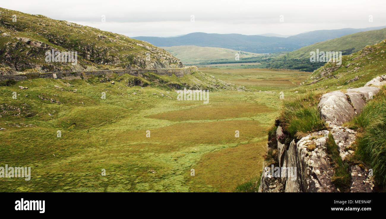 Grüne Hügel und die Straße auf dem Hügel. Einen malerischen Blick auf den Kerry Mountains und der Umgebung in der Grafschaft Kerry. Im Alter von Wirkung. Landschaft entlang der R Stockfoto
