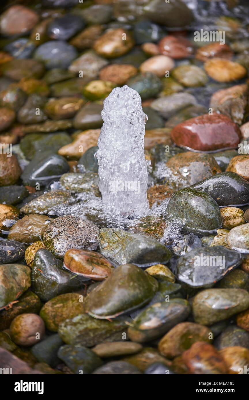 Springbrunnen und nassen Kieselsteinen Stockfoto