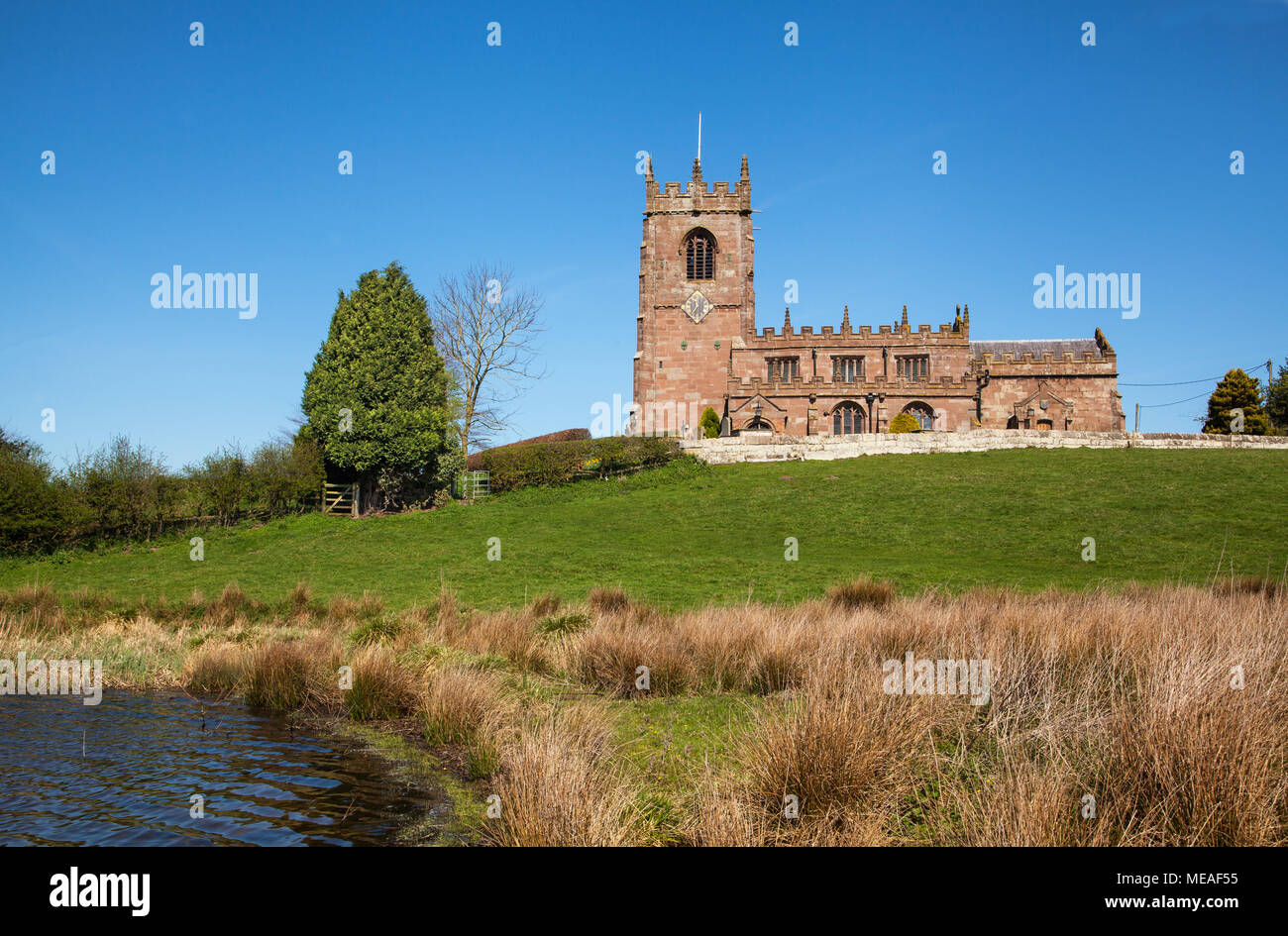 Die Pfarrkirche St. Michael auf einem Hügel oberhalb des Großen bloße im Cheshire Dorf Marbury in die hügelige Landschaft und Ackerland eingestellt Stockfoto