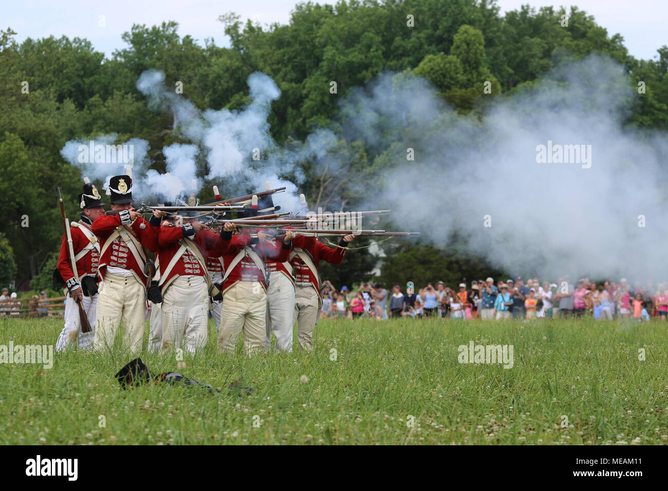 Britische löten Reenactors feuern Musketen mit spectaors im Hintergrund während des Krieges von 1812 reenactment Feier Stockfoto