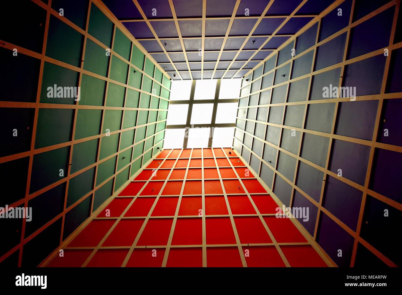 Perspektive abstract von Sonnenlicht durch eine Decke Oberlicht beleuchtet die grüne, rote und blaue geometrische Decke einer Atrium Stockfoto
