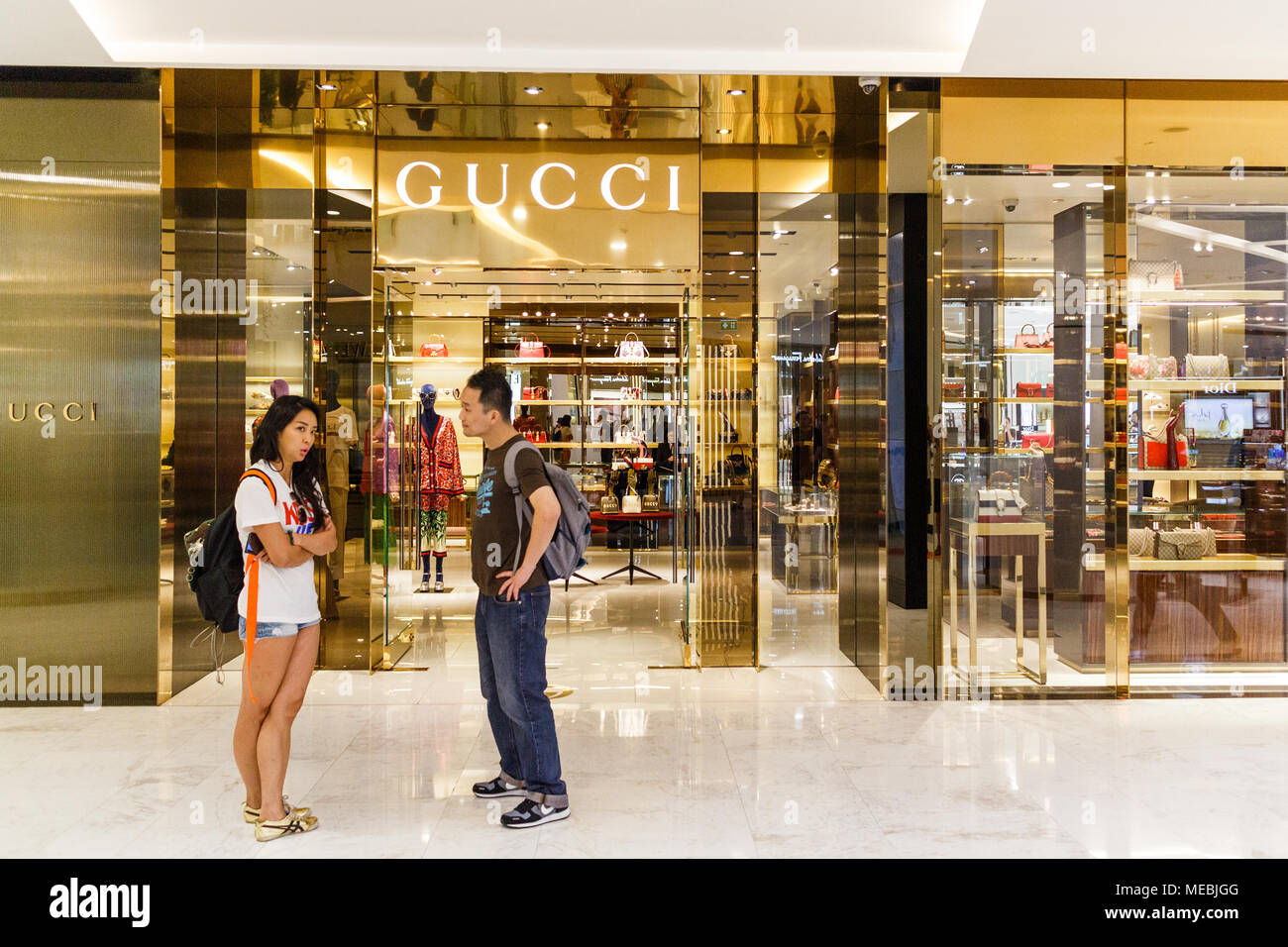 Ein junges Paar in der Diskussion außerhalb eines Gucci shop, Emporium Shopping Mall, Bangkok, Thailand Stockfoto