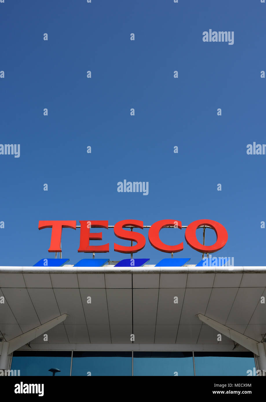 Tesco Supermarket-Logo auf weißem Dachblech auf tesco Store in strahlendem Sonnenschein und klarem blauen Himmel ohne Wolken in Bury lancashire uk montiert Stockfoto