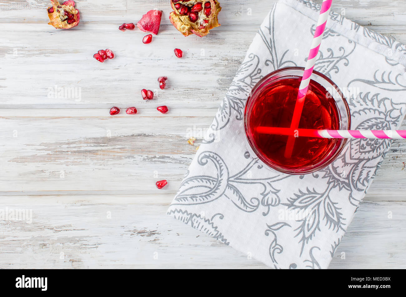 Frischen Granatapfelsaft in ein Glas mit Obst Granatäpfel auf weißem Holz- Hintergrund Stockfoto