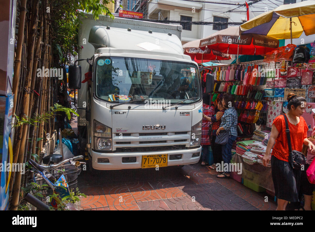 Ein Lkw drückt auf seine Weise hinter den Marktständen auf einer Lane in Chinatown, Bangkok, Thailand Stockfoto