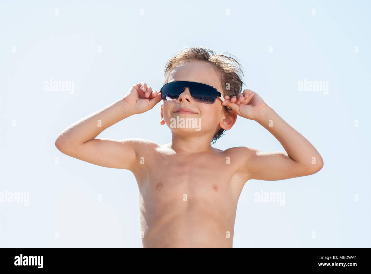Glücklich lächelnde schöne kleine Kind in Sonnenbrille im sonnigen Sommertag Stockfoto