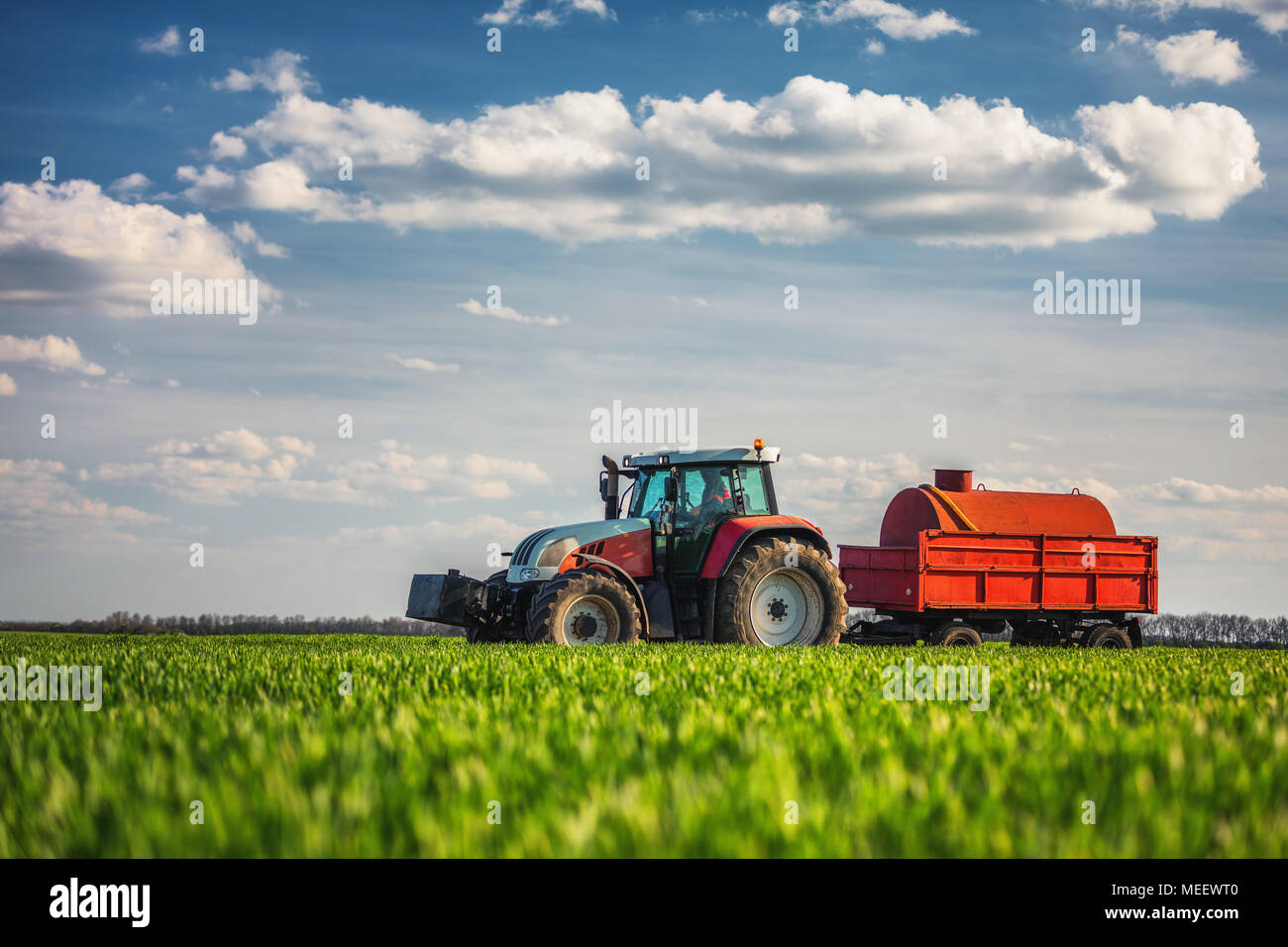 Landwirtschaftlichen Traktor Pflügen und Spritzen auf dem Feld Stockfoto