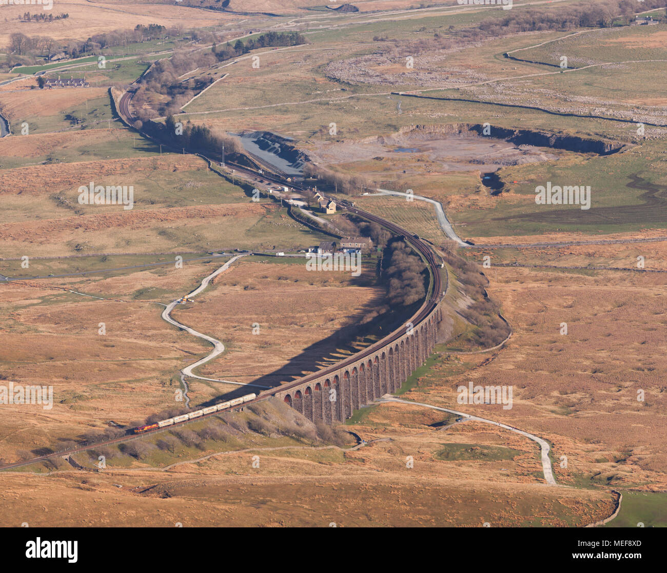 Ein DB Cargo Class 66 Lokomotive Kreuzung Ribblehead Viadukt mit einem Güterzug Zement Durchführung vom Gipfel des Whernside gesehen Stockfoto