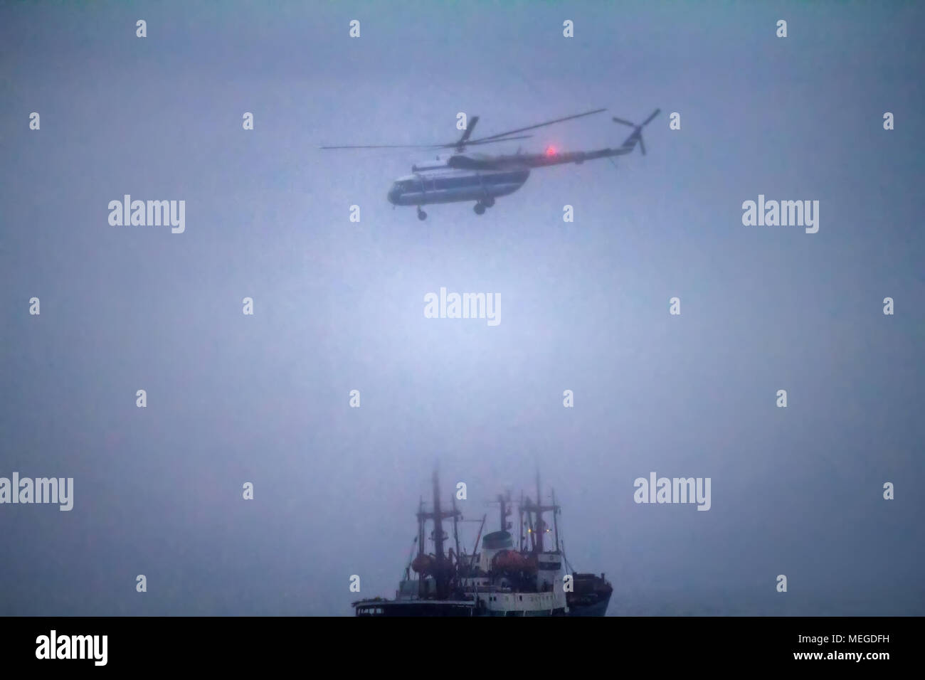 Gefährliche Arbeit des Arktischen Piloten. Hubschrauber Mi-8 führt die Be- und Entladung an Bord icebreaker bei dichtem Nebel. Kara Strait, Arktis Stockfoto