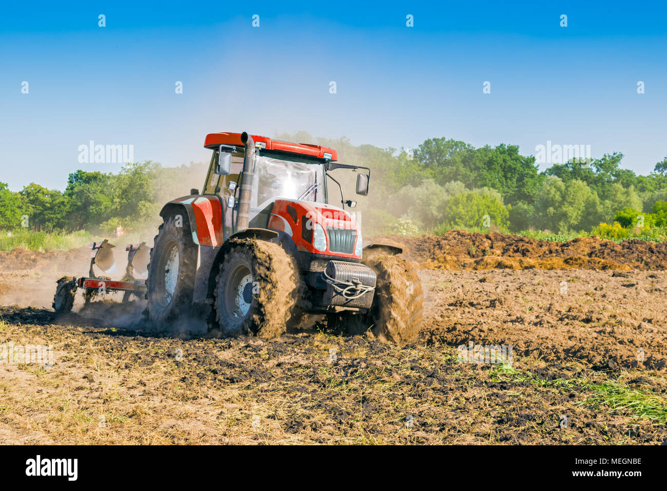 Roter Traktor fahren durch Arbeitnehmer während der Feldarbeit auf dem Ackerland im Sommer in Szalsza, Schlesischen Hochland, Polen. Stockfoto