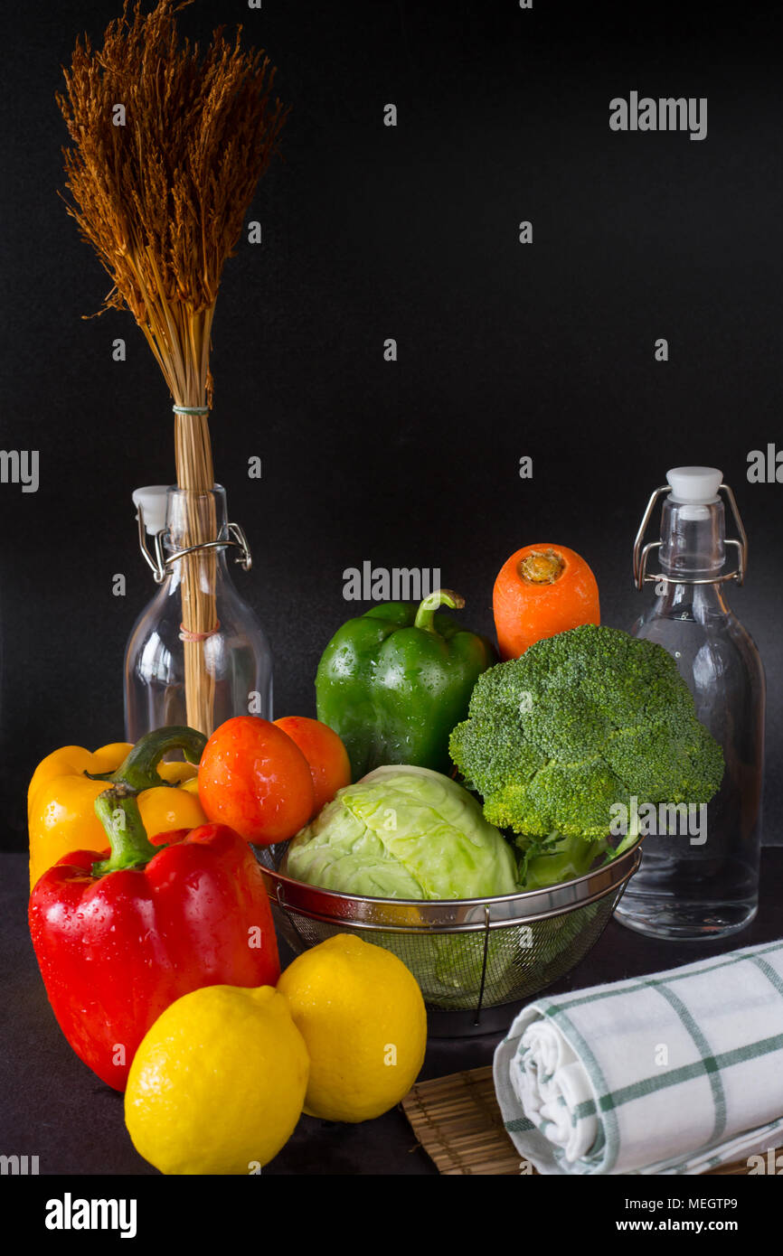 Rote Reife Paprika, Tomate, Zitrone und Brokkoli auf schwarzem Hintergrund. Stockfoto