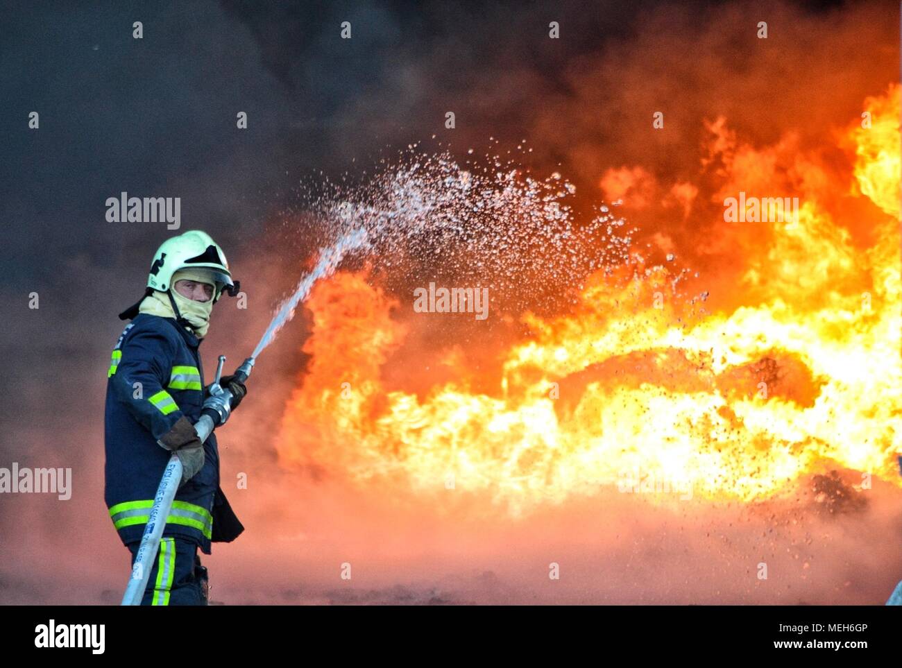 Feuerwehrmann kämpft mit Feuer, Feuerwehr auf der Suche nach Überlebenden. Riesige Flammen brannte ein Recyclingunternehmen in Tirana, Feuerwehrmann Löschmittel der Flamme Stockfoto