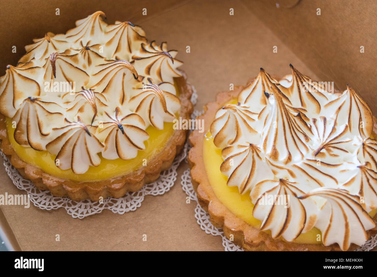 Zwei Lemon Meringue Torten in einer Box, auf fancy Deckchen Stockfoto