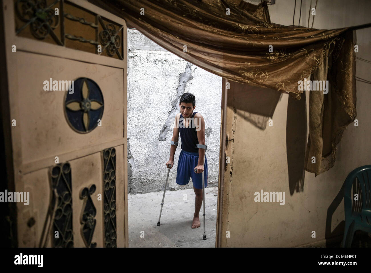 Palästinensischen Flüchtlinge, Mohammed Al-Ajorri, der sein Bein bei Zusammenstößen an der Grenze zwischen Israel und Gaza verloren, gibt seine Familie Haus Krücken, in Flüchtlingslager Jabaliya, nördlichen Gazastreifen, 18. April 2018. Al-Ajorri, 17, war in seinem Bein durch eine israelische Schüsse in der Nähe der Grenze zwischen dem Gazastreifen und Israel am 30. März 2018 verletzt und hatte sein rechtes Bein amputiert, nachdem es Zugang zu einer ausreichenden medizinischen Versorgung außerhalb des Gazastreifens zu haben. Foto: Wissam Nassar/dpa Stockfoto