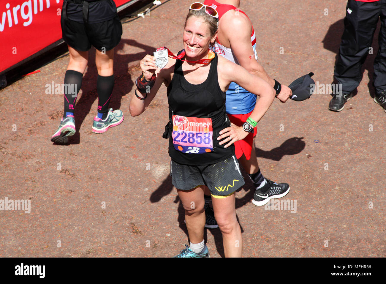 London, UK, 22. April 2018. Marathonläufer mit Ihr finisher Medaille Credit: Alex Cavendish/Alamy leben Nachrichten Stockfoto