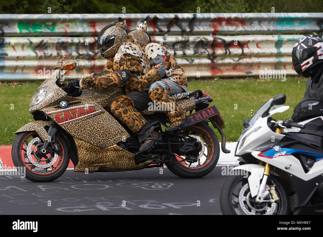 22 April 2018, Deutschland, Nürburg: ein Paar auf einem Motorrad angetan  mit Tierdruck, die an der Parade für in dieser Saison auf dem Nürburgring  starten unter dem Motto "Anlassen" (Lit. "Es halten").