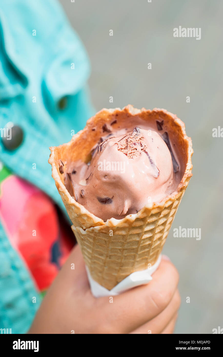 Horn mit Schokolade Eis in der Hand des Kindes schließen nach oben Stockfoto