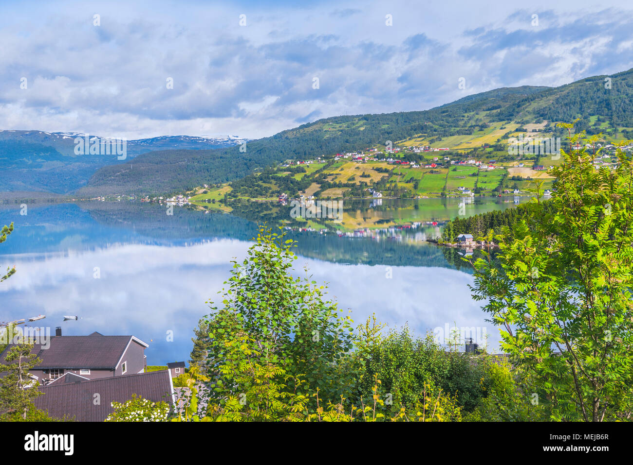 See Hafslovatnet, Hafslo, Norwegen, Blick über den See mit Spiegelung der bunten Landschaft, Dörfer und Wiesen im Wasser Stockfoto