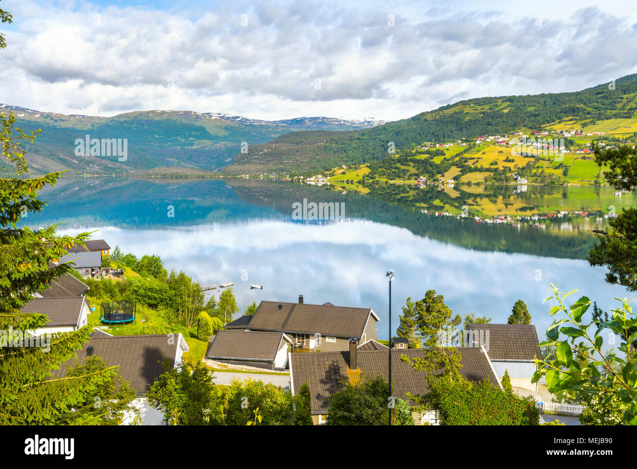 See Hafslovatnet, Hafslo, Norwegen, Blick über den See mit Spiegelung der bunten Landschaft, Dörfer und Wiesen in der Nähe des Lustrafjorden Stockfoto