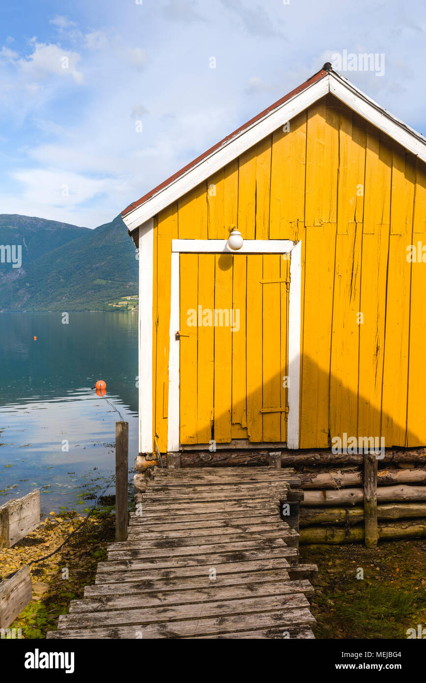 Gelbe Boot Haus, Norwegen, Steg am Sognefjorden, idyllische Lage am Fjord in das Dorf Solvorn, Lustrafjorden, Sogn og Fjordane county Stockfoto