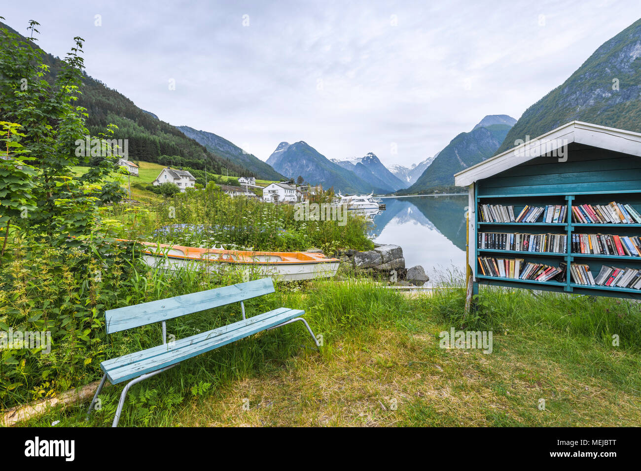 Outdoor Bibliothek und Sitzbank am Fjord, Fjaerlandsfjorden, Norwegen, öffentlichen Bücherregal und Boot am Ufer mit malerischer Umgebung Stockfoto